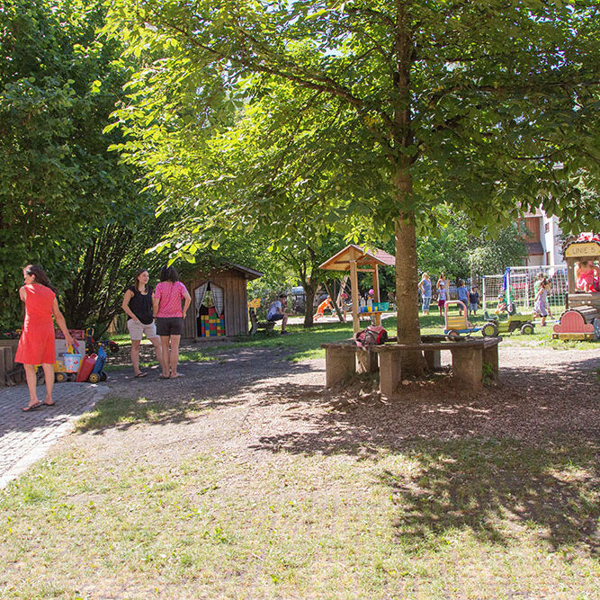 Der Garten der KiTa Eurasburg in dem Kinder spielen und die Betreuer auf sie aufpassen.
