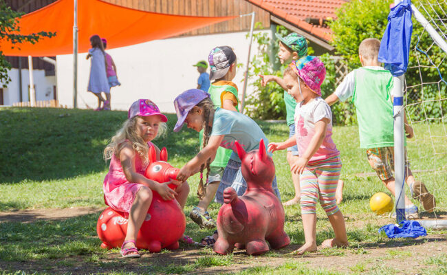 federleicht-design-9992 Kinder spielen im Garten des Kindergartens.