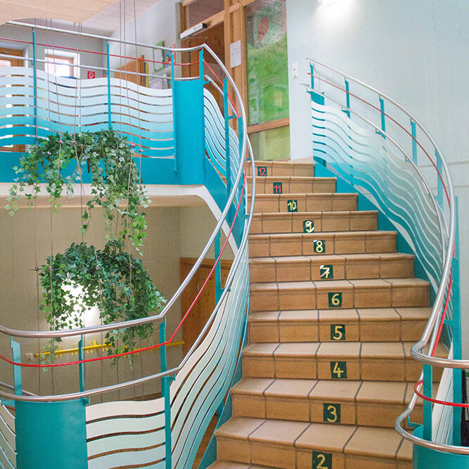 Die Treppe zu den oberen Räumen der KiTa Eurasberg mit Zahlen an den Stufen, damit die Kinder zählen üben können.